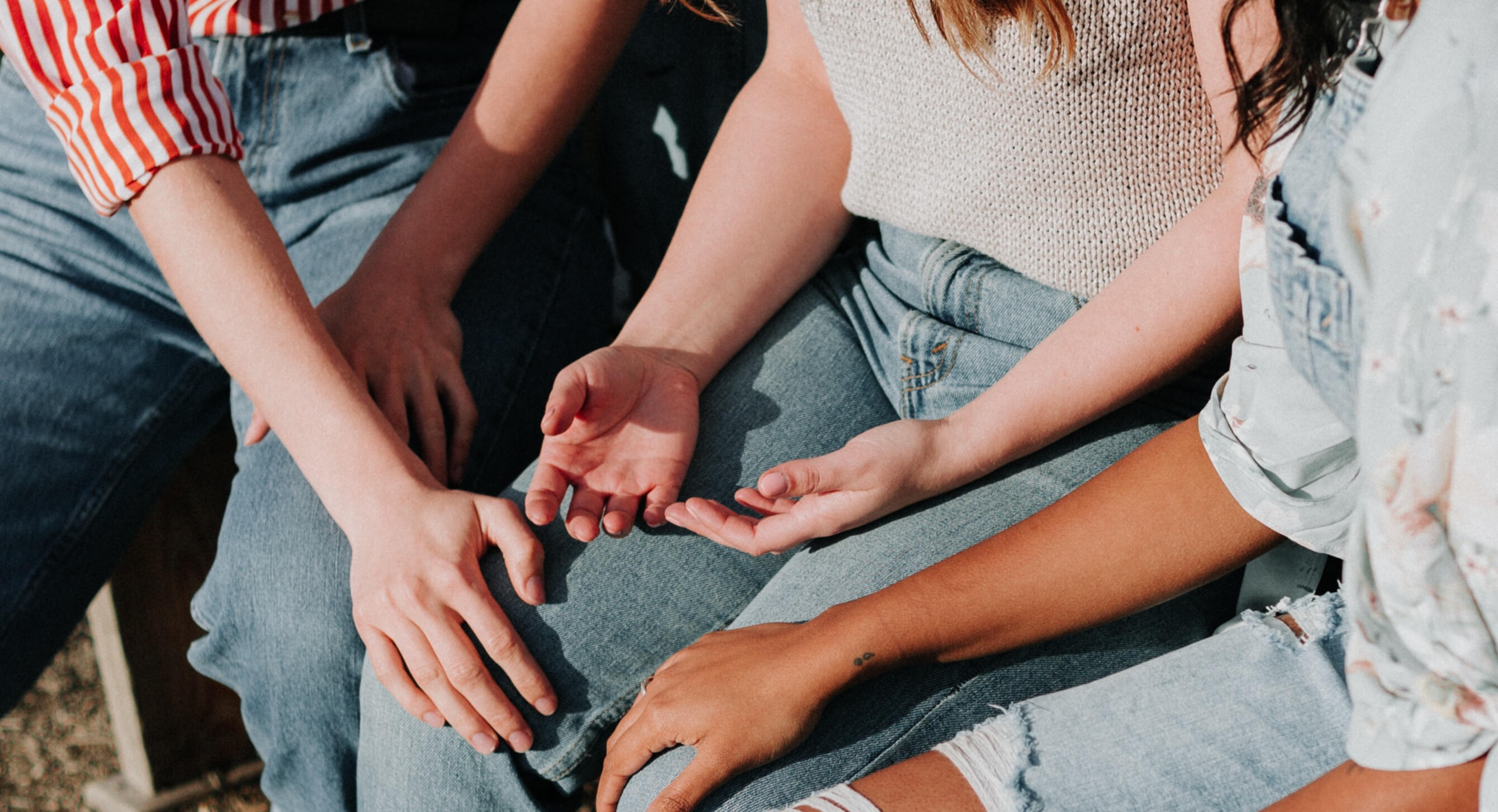 Woman in distress being comforted by two female friends.